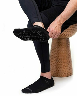 A man sitting and putting on a pair of gripper socks