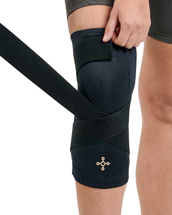 woman wrapping her knee in brace